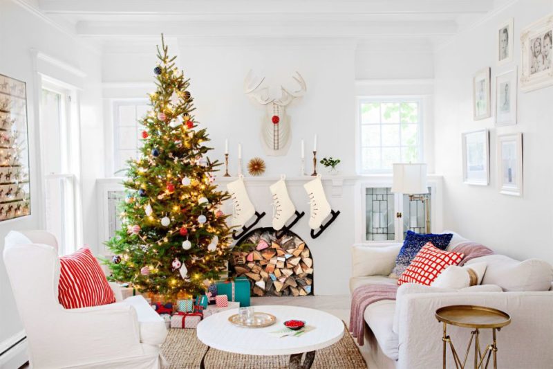 Árvore de natal muito bem decorada, em uma sala bem aconchegante.